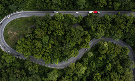 Aerial view green forest with car on the asphalt road, Car drive on the road in the middle of forest